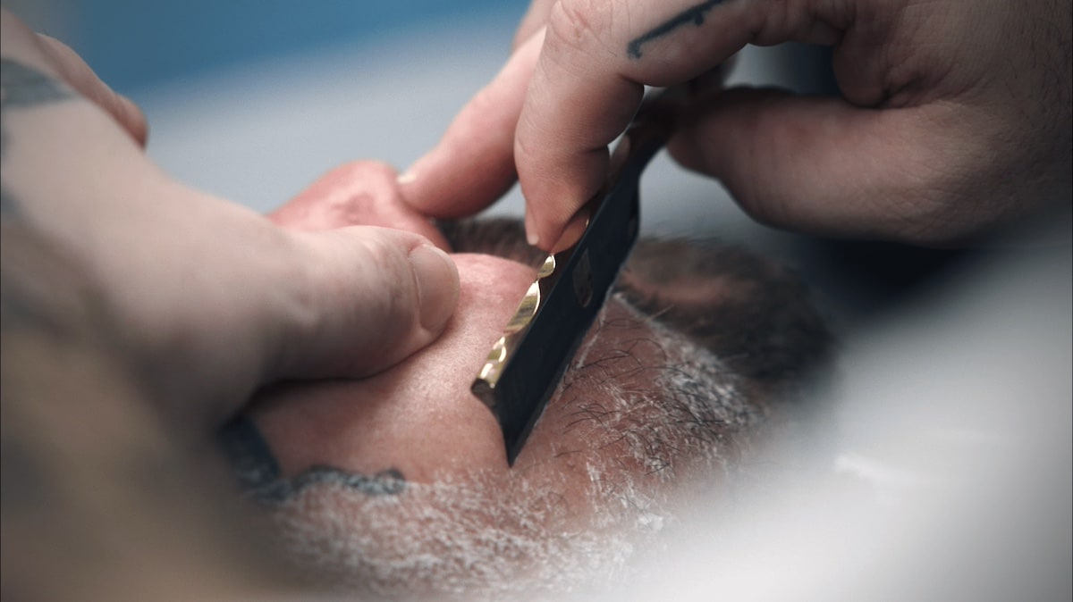 Barbier rasiert Kunde mit einem Rasiermesser